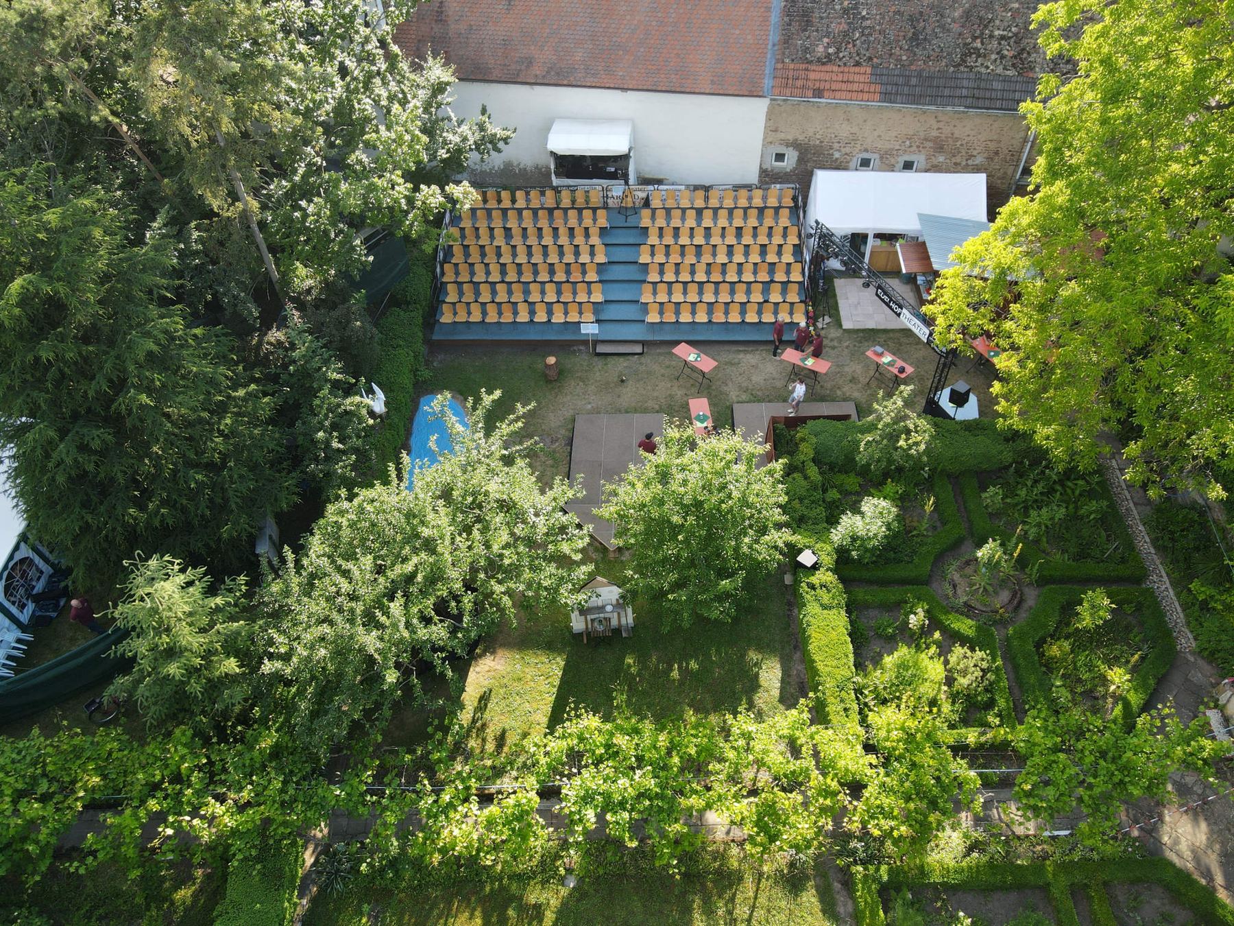 Der Pfarrgarten in Kirrweiler aus der Luft, mit der Tribüne zwischen alten Bäumen